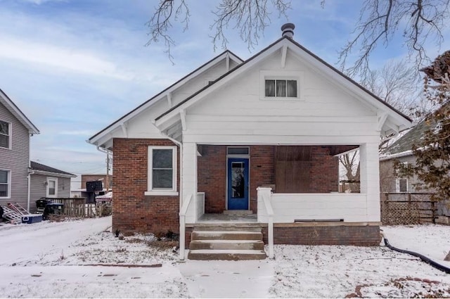 bungalow-style house with fence and brick siding