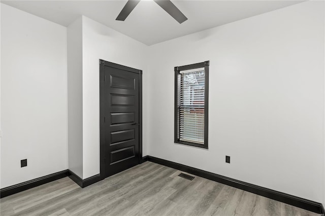 spare room featuring visible vents, ceiling fan, light wood-style flooring, and baseboards