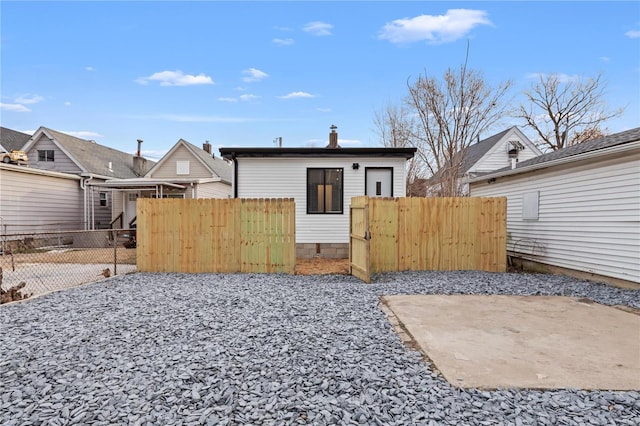 back of property featuring a gate and fence