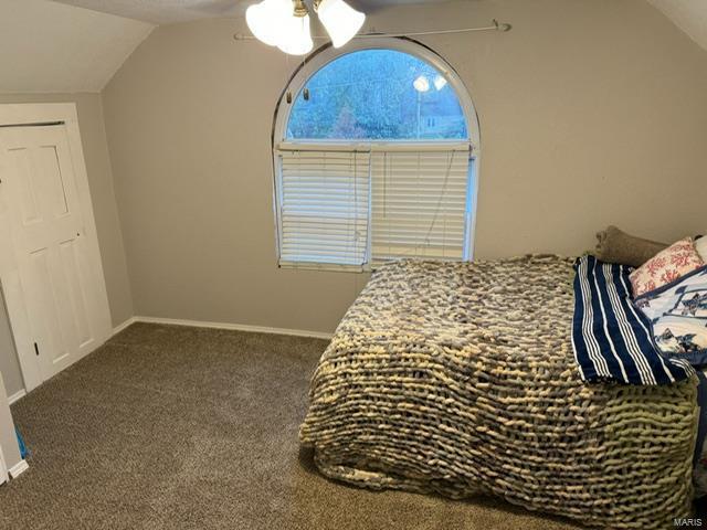 carpeted bedroom with vaulted ceiling and ceiling fan