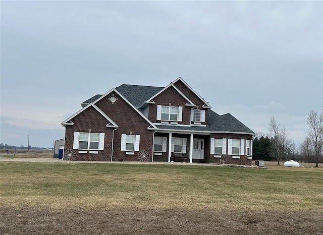 craftsman-style home with a front lawn, central AC, and brick siding