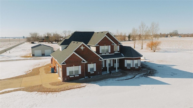 view of front of house featuring an outbuilding, central AC unit, brick siding, and a garage