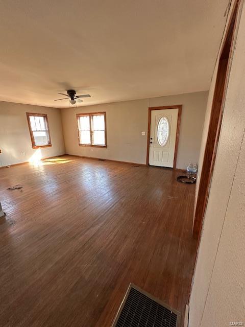 entrance foyer with baseboards, ceiling fan, visible vents, and wood finished floors