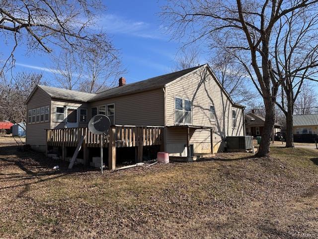 rear view of property with a chimney and a wooden deck