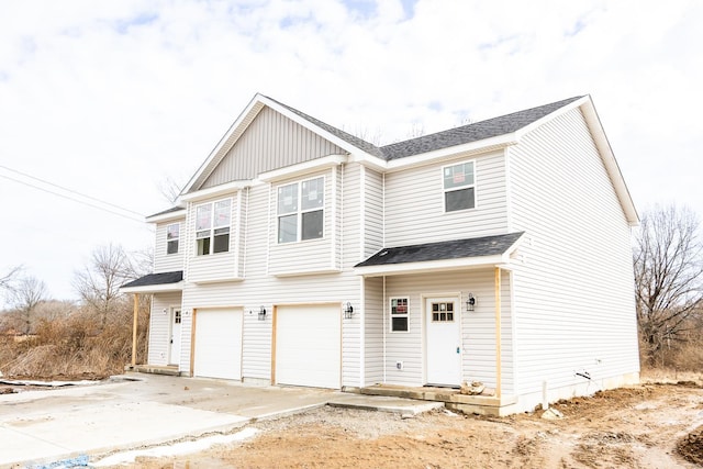 view of front of home featuring board and batten siding, concrete driveway, a shingled roof, and an attached garage