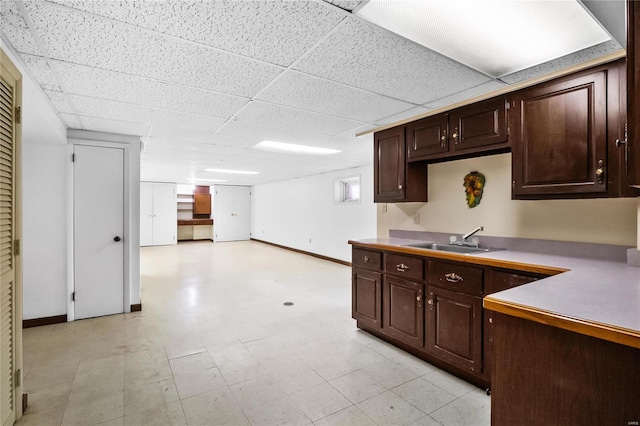 kitchen featuring sink, a paneled ceiling, and dark brown cabinetry