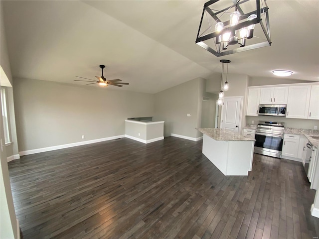 kitchen featuring stainless steel appliances, white cabinets, open floor plan, a center island, and decorative light fixtures