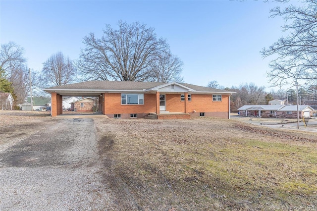 single story home featuring an attached carport, brick siding, and driveway