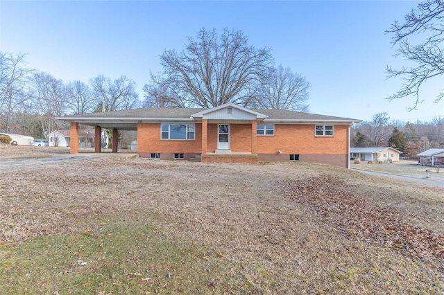 ranch-style home featuring brick siding and an attached carport