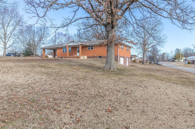 ranch-style home featuring a garage, a front yard, and brick siding