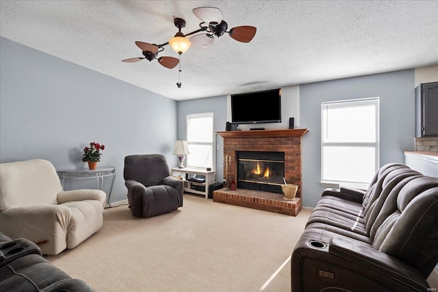 living room featuring a ceiling fan, a brick fireplace, light carpet, and a textured ceiling