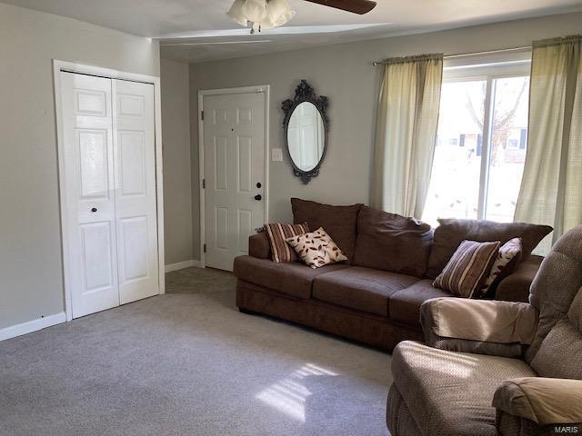 carpeted living room featuring ceiling fan and baseboards