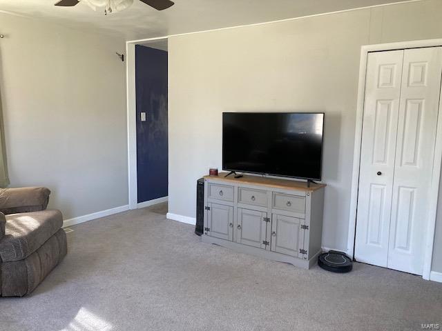 living room featuring ceiling fan, carpet, and baseboards