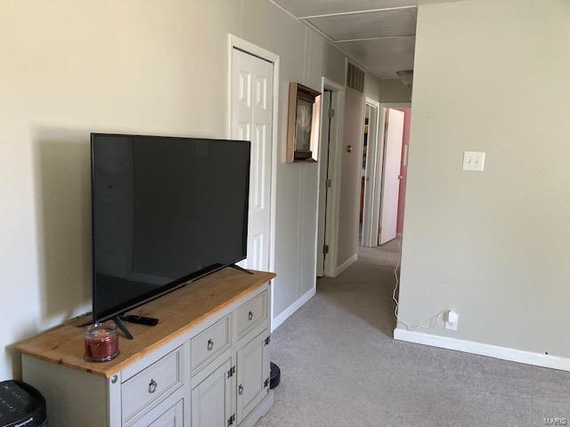 interior space featuring light carpet, visible vents, and baseboards