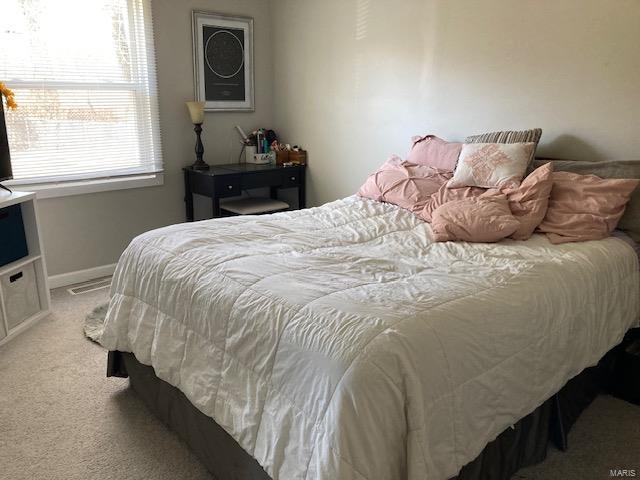 bedroom featuring light colored carpet and baseboards