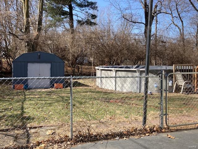 view of yard with a shed, fence, and an outdoor structure