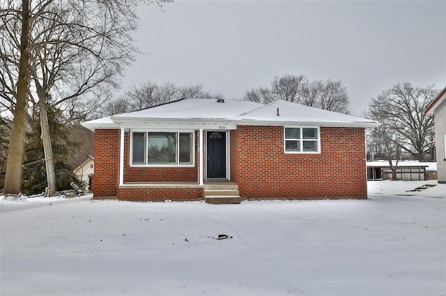 view of front of house with entry steps and brick siding