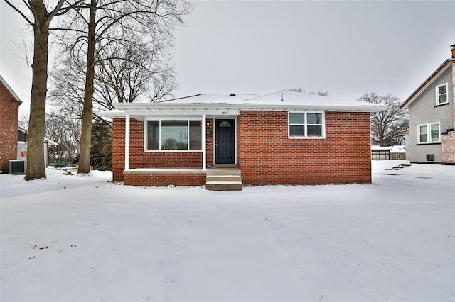 bungalow-style home with central AC and brick siding