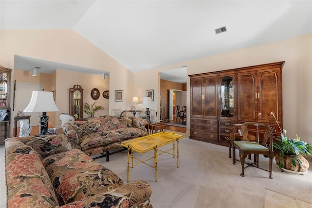 living room featuring vaulted ceiling, visible vents, and light carpet