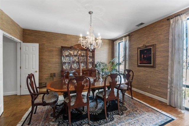 dining area featuring a chandelier, visible vents, and baseboards