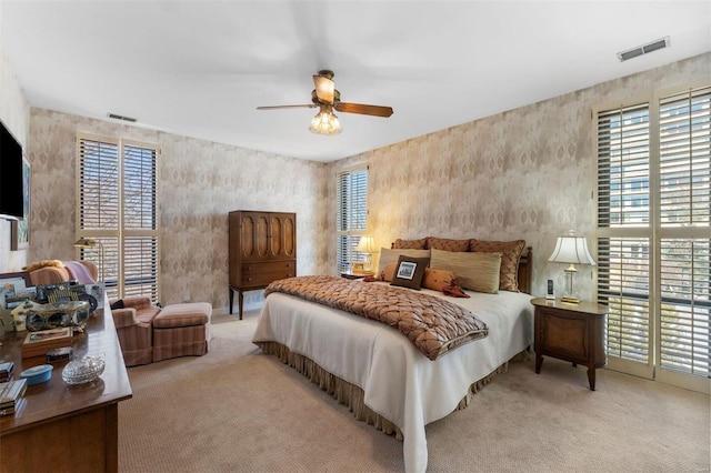 carpeted bedroom with visible vents and a ceiling fan