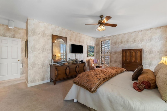 carpeted bedroom featuring wallpapered walls, a ceiling fan, and baseboards