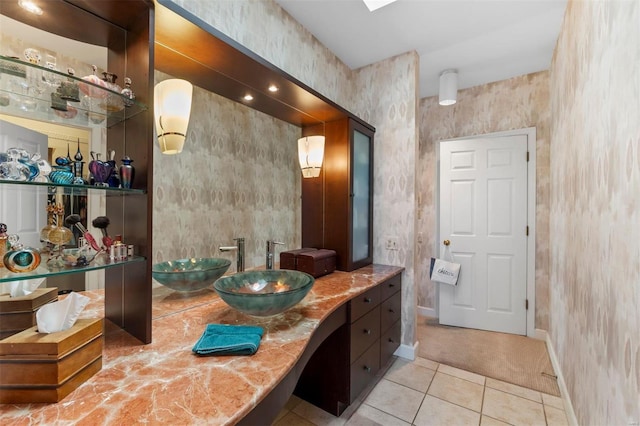 bathroom with tile patterned floors, vanity, and baseboards