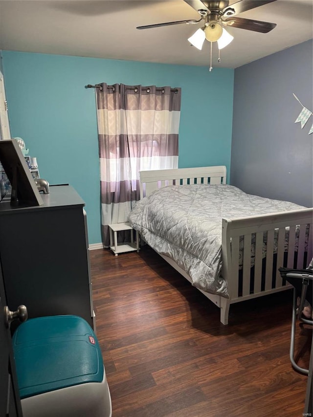 bedroom with dark hardwood / wood-style flooring and ceiling fan