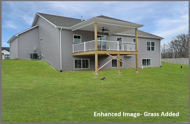 back of property with a deck, a yard, and ceiling fan