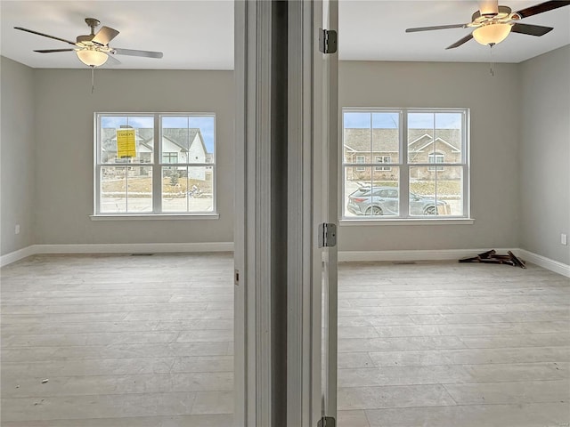 empty room featuring light wood-type flooring and ceiling fan