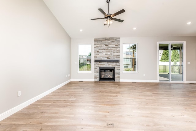 unfurnished living room with light hardwood / wood-style flooring, ceiling fan, vaulted ceiling, and a fireplace