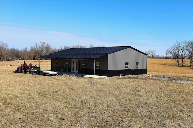 view of outdoor structure with a carport and a lawn