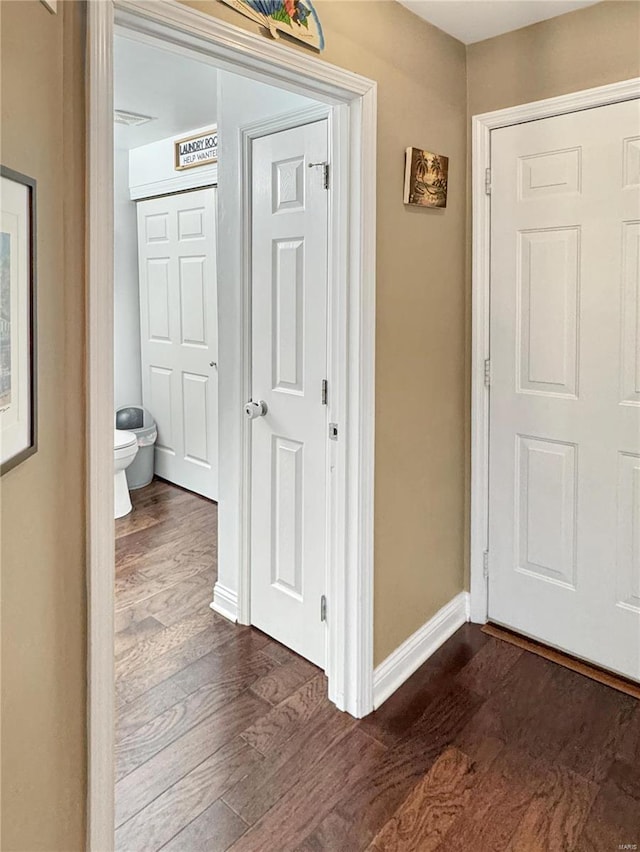 corridor with dark hardwood / wood-style flooring