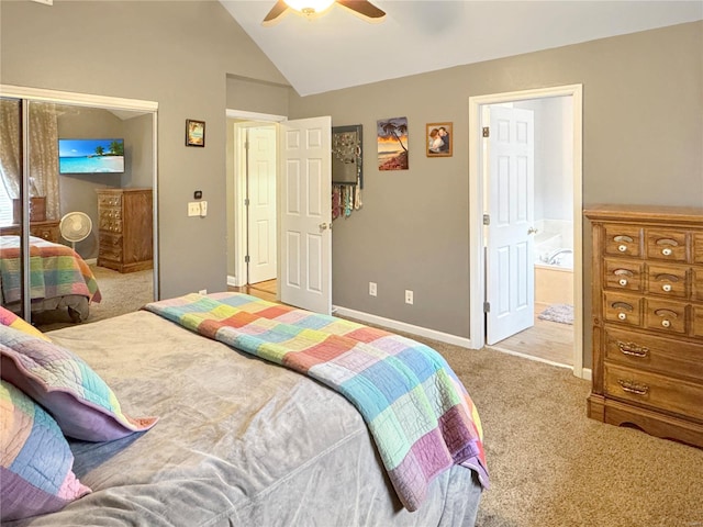 bedroom with lofted ceiling, a closet, ceiling fan, light carpet, and ensuite bathroom