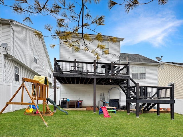 rear view of house featuring a yard, a deck, and a playground