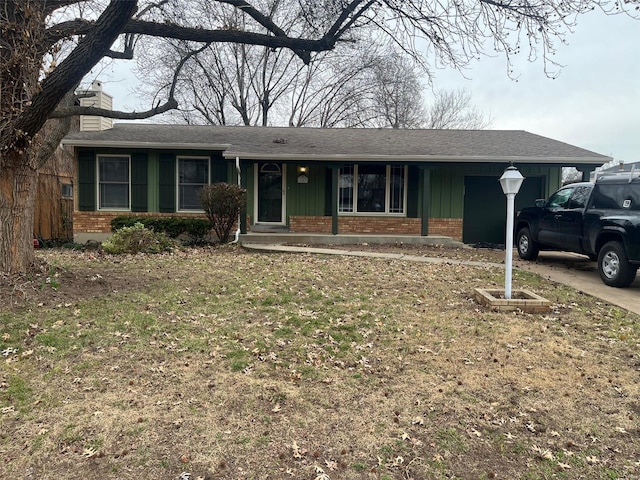 ranch-style home featuring brick siding, a chimney, board and batten siding, a garage, and driveway