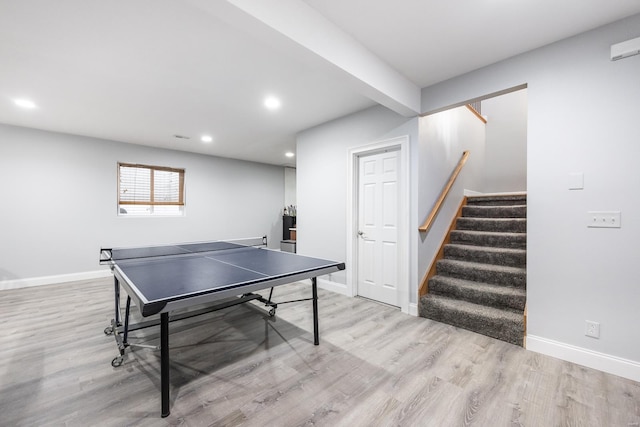 recreation room featuring beamed ceiling and light hardwood / wood-style floors