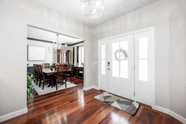 entrance foyer with an inviting chandelier and dark hardwood / wood-style floors