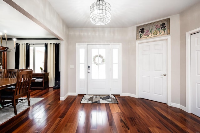 foyer entrance featuring dark wood-type flooring and an inviting chandelier