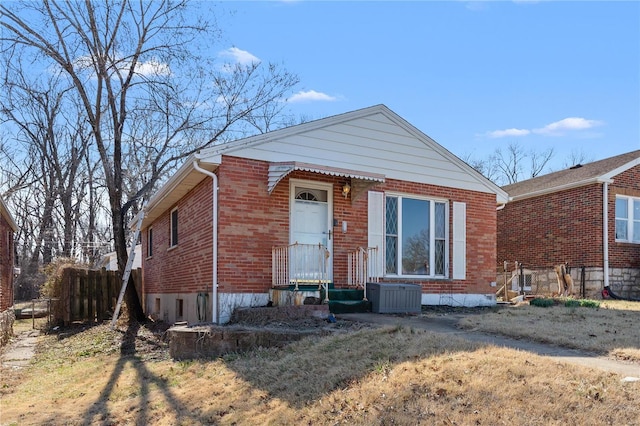 view of front of property with central air condition unit, fence, and brick siding