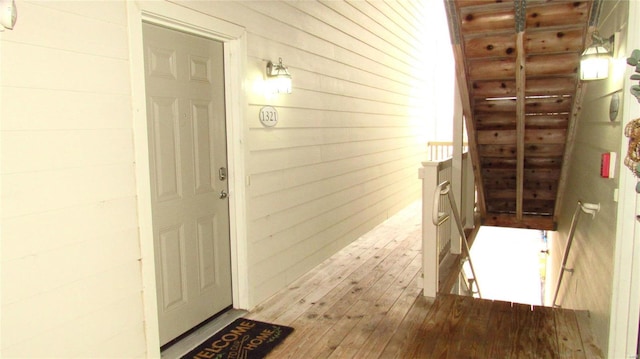 interior space with light wood-type flooring and wood walls