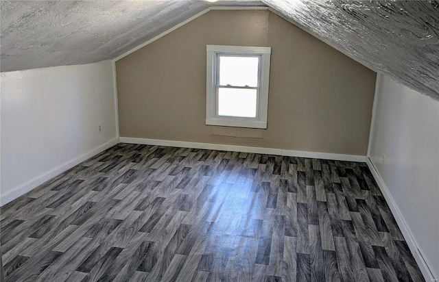 bonus room with a textured ceiling, dark wood-type flooring, lofted ceiling, and baseboards