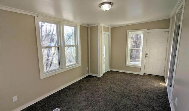 foyer with baseboards and dark carpet