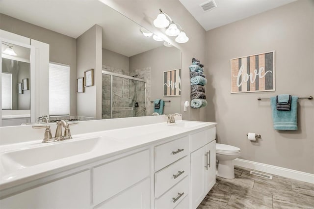 bathroom with toilet, a shower with shower door, and vanity