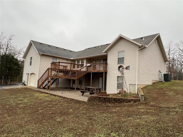 rear view of property featuring central AC, a deck, a garage, and a yard