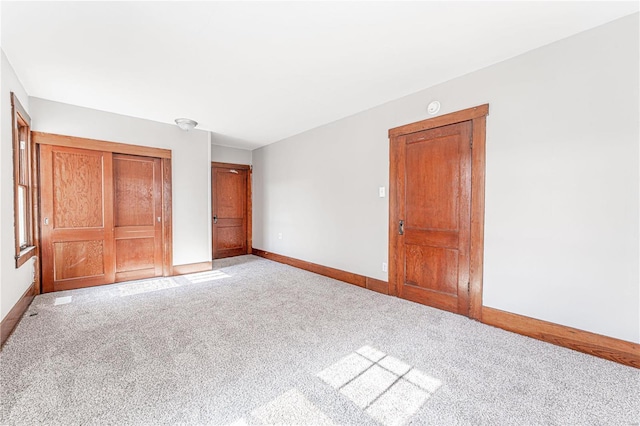 unfurnished bedroom with a closet and light colored carpet