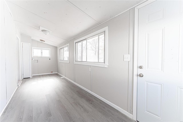 unfurnished room featuring light hardwood / wood-style flooring and lofted ceiling