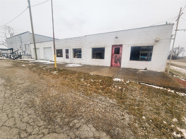 view of front facade with concrete block siding and a garage