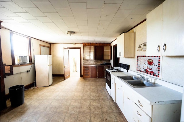 kitchen with freestanding refrigerator, electric range, a sink, light countertops, and white cabinets