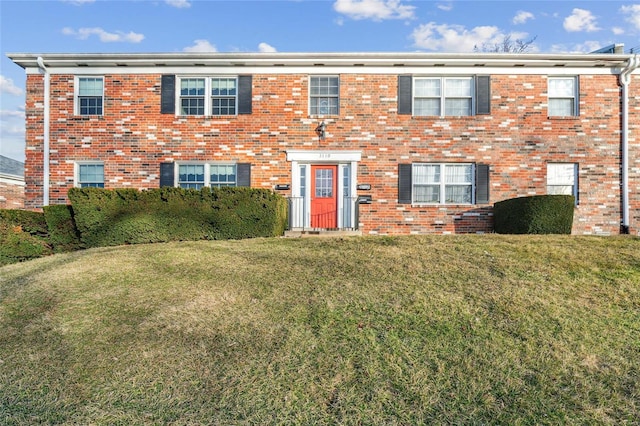 view of front of home with brick siding and a front lawn